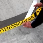 Černo-žlutá korundová protiskluzová páska s potiskem FLOMA Attention Danger - 18,3 m x 7,5 cm a tloušťka 0,7 mm